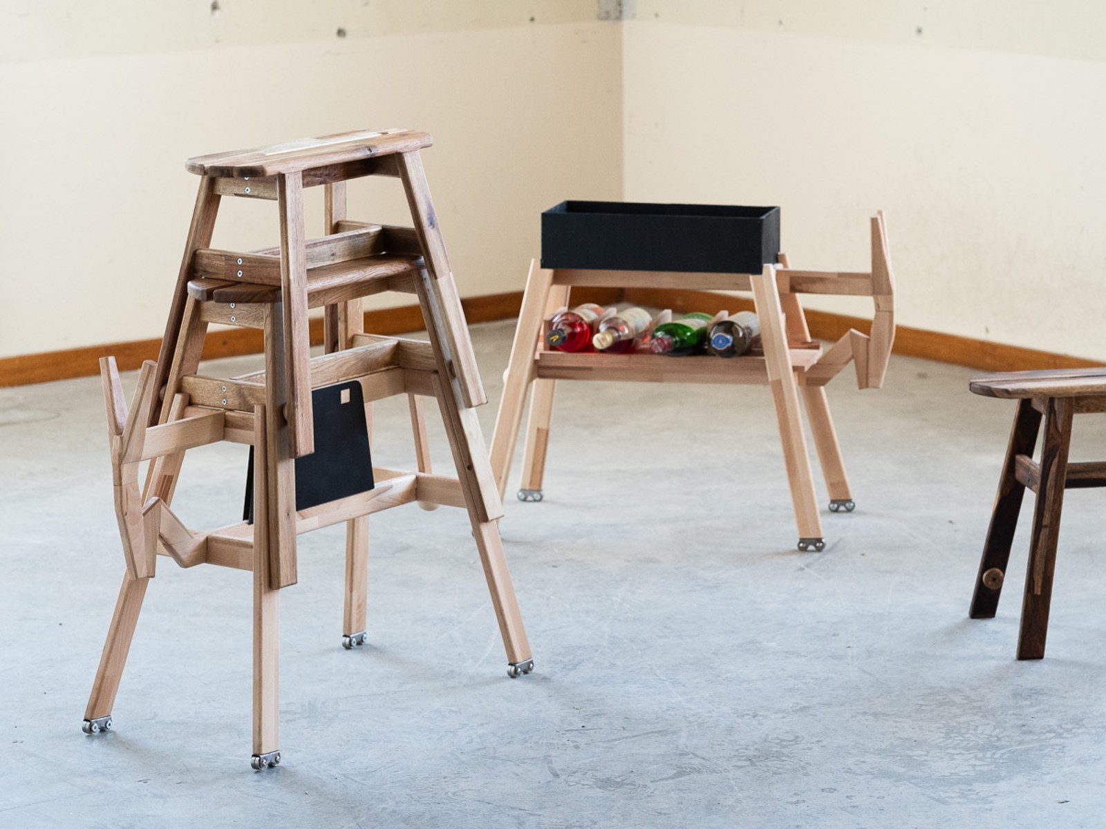 Donkey by NOEMAR — the stacked step-stool and the bottle cart seen from across the room.