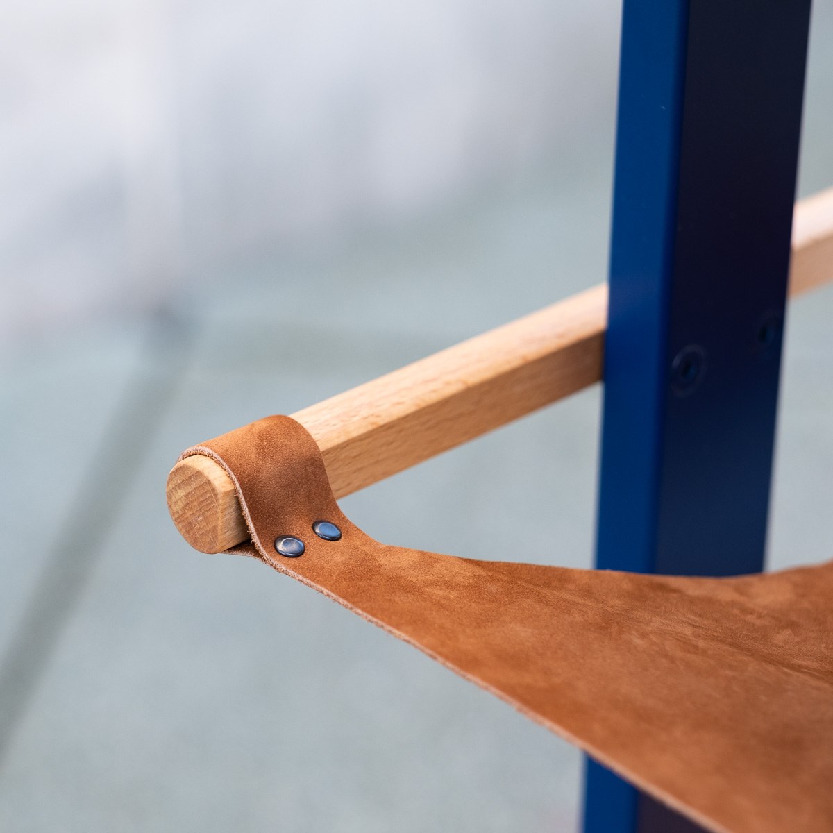 Tendere — close detail of the leather sling’s stitched loop around the dowel.