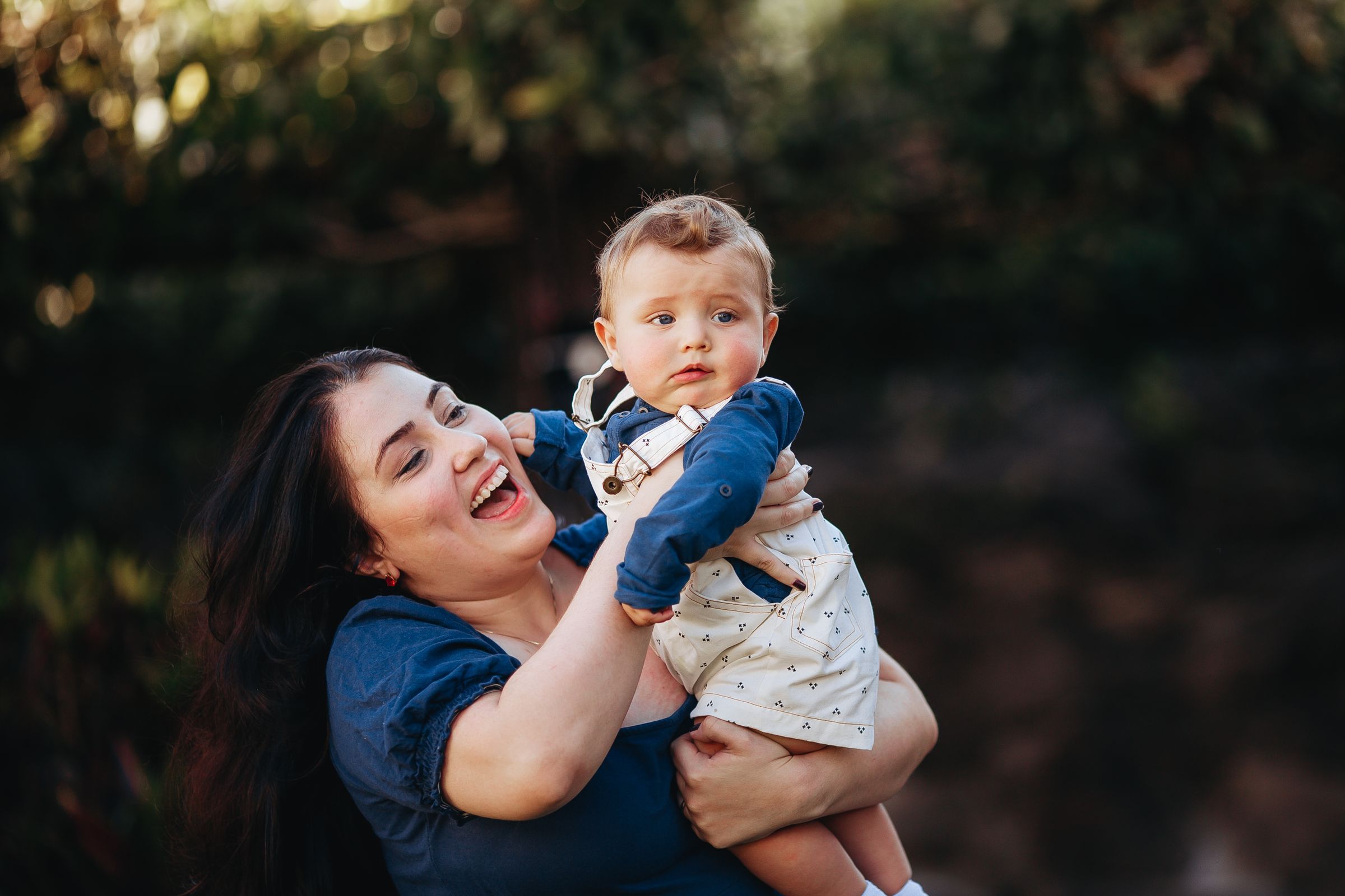 Happy mother holding her baby outdoors