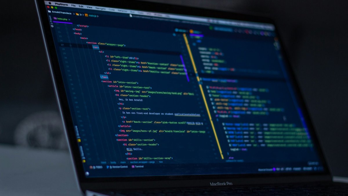 Laptop met programmeercode op het scherm in een donkere kamer