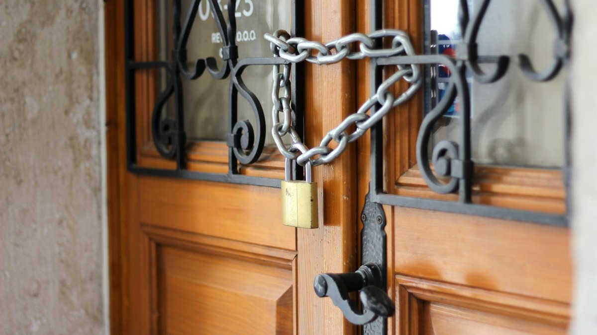 Wooden door with wrought-iron window secured with a chain and padlock