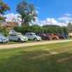 Alignement de 2CV colorées sur chemin de campagne