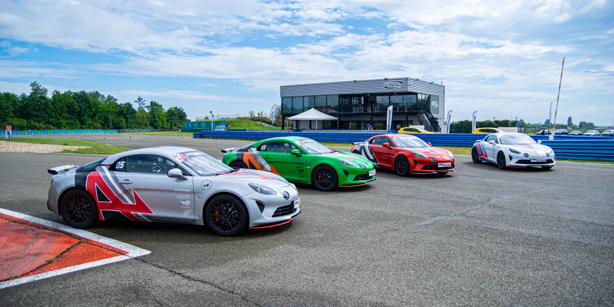 Quatre Alpine alignées devant le paddock