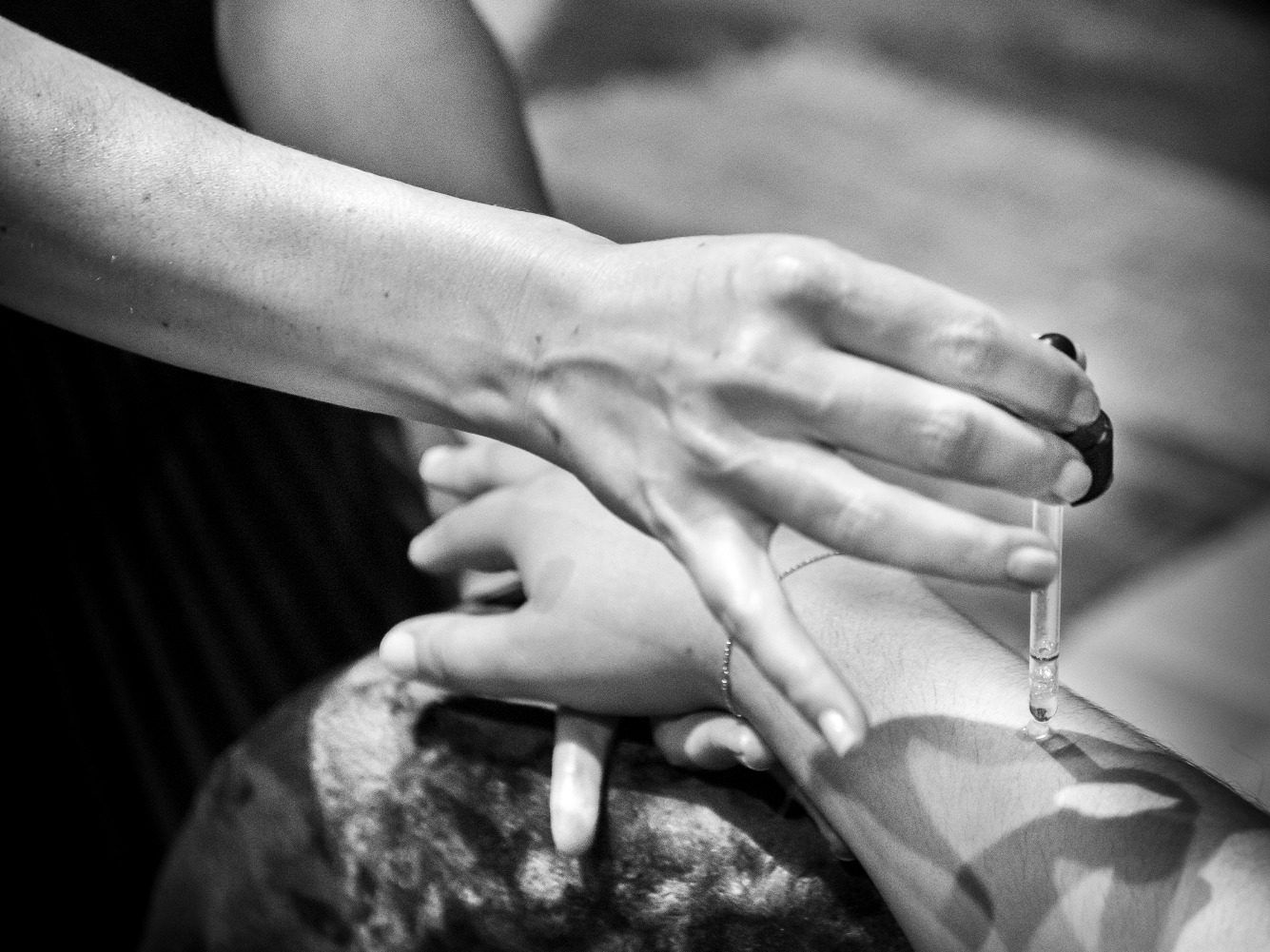 Application d'huile parfumée sur poignet, ambiance feutrée