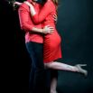 Couple en tenue rouge enlacé, fond noir