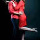 Couple en tenue rouge enlacé, fond noir
