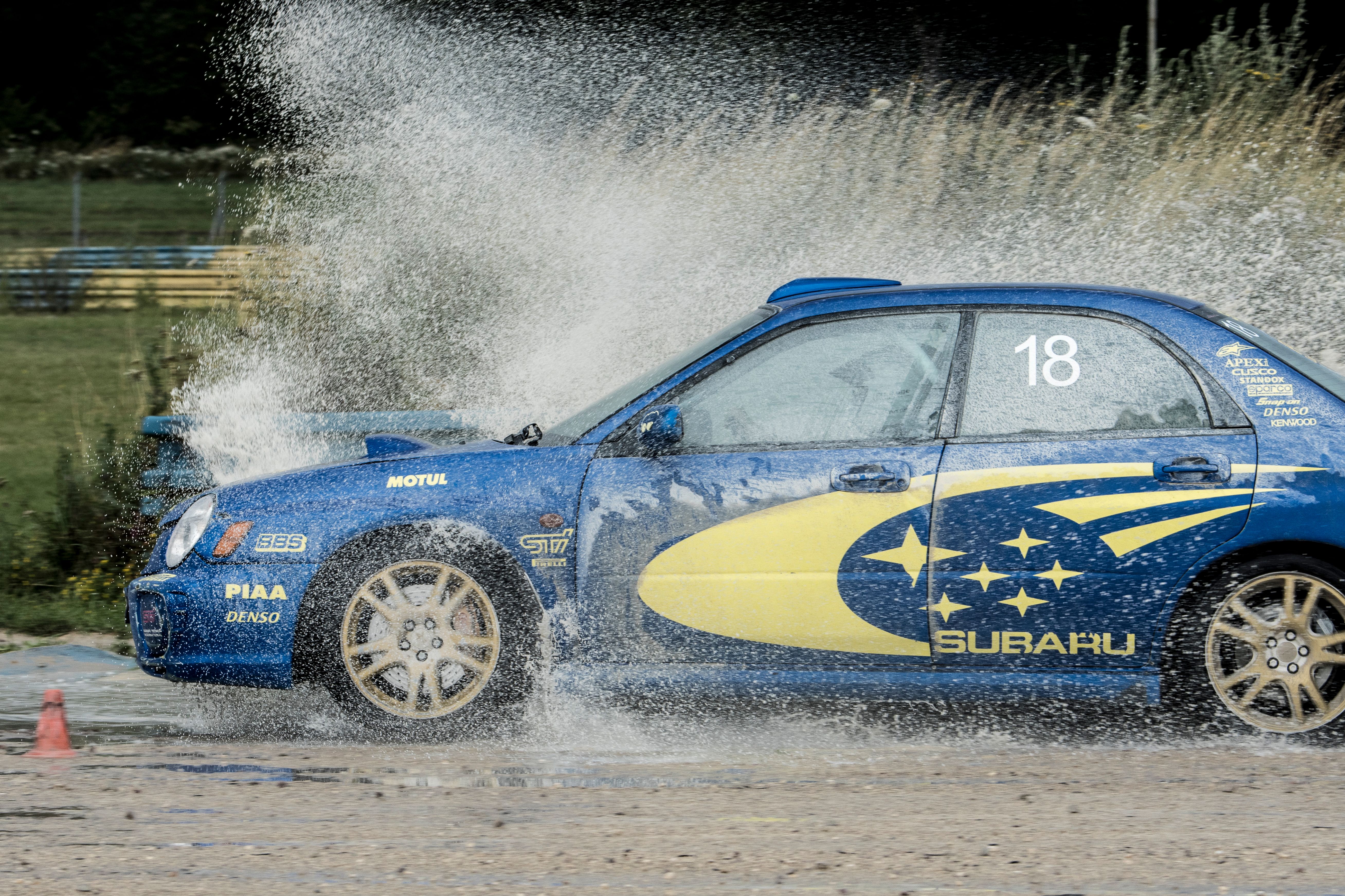 Subaru Impreza bleue en gerbe d'eau sur circuit