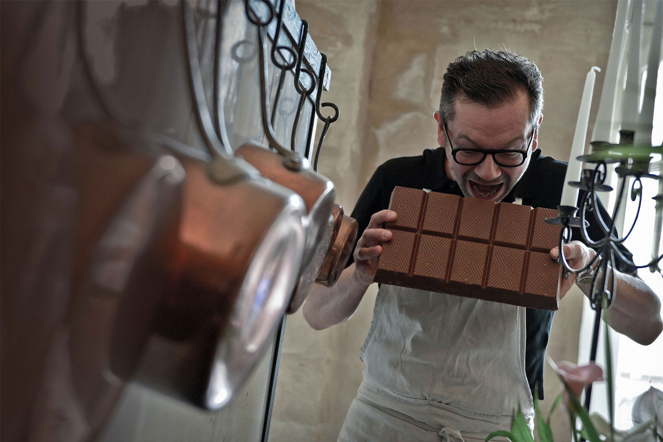 Chocolatier mordant une grande tablette de chocolat