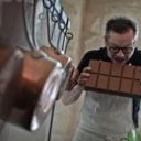 Chocolatier mordant une grande tablette de chocolat