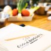 Tablier École Ducasse posé près de légumes frais