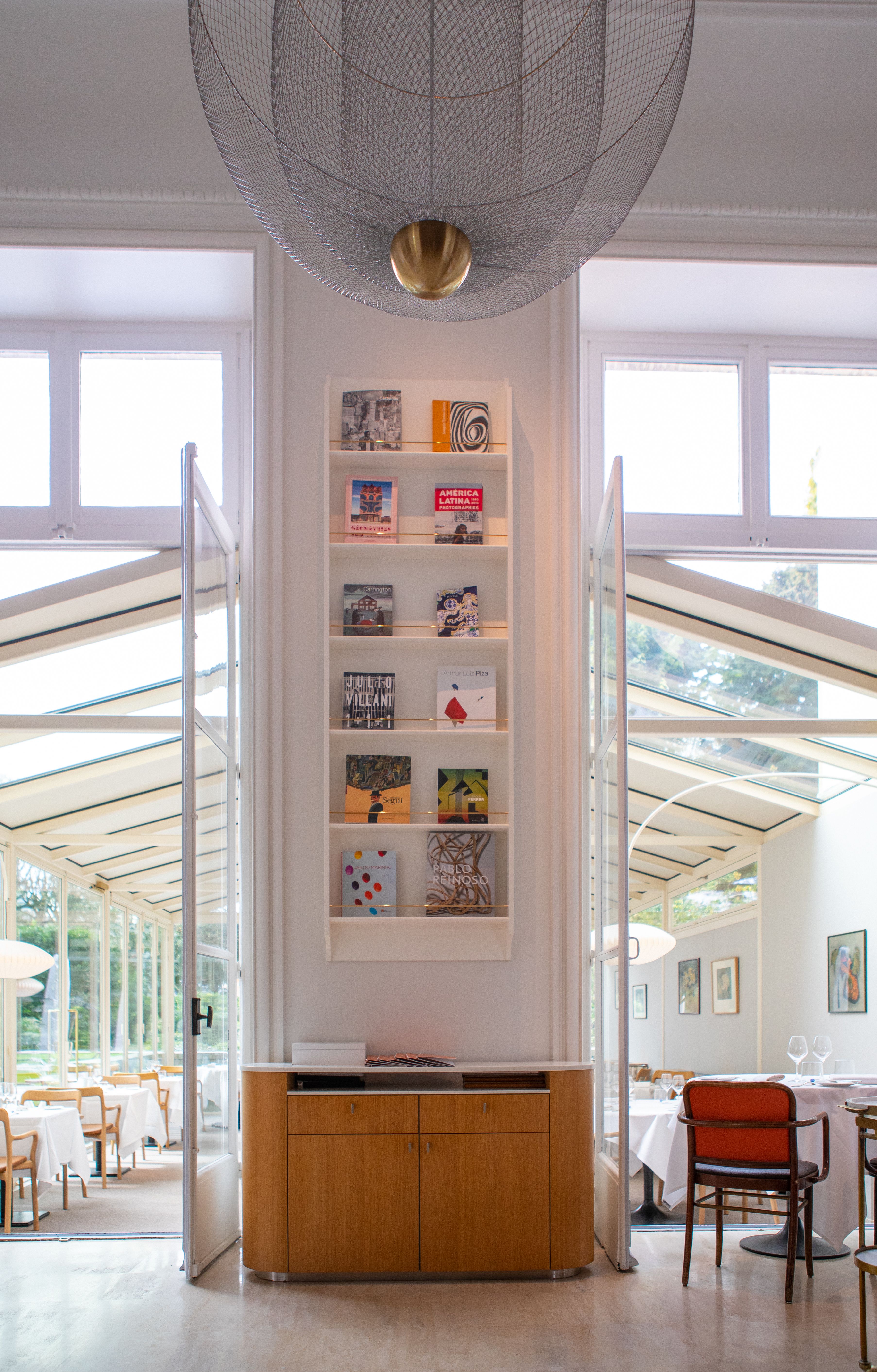 Salle lumineuse avec bibliothèque art et chaise rouge