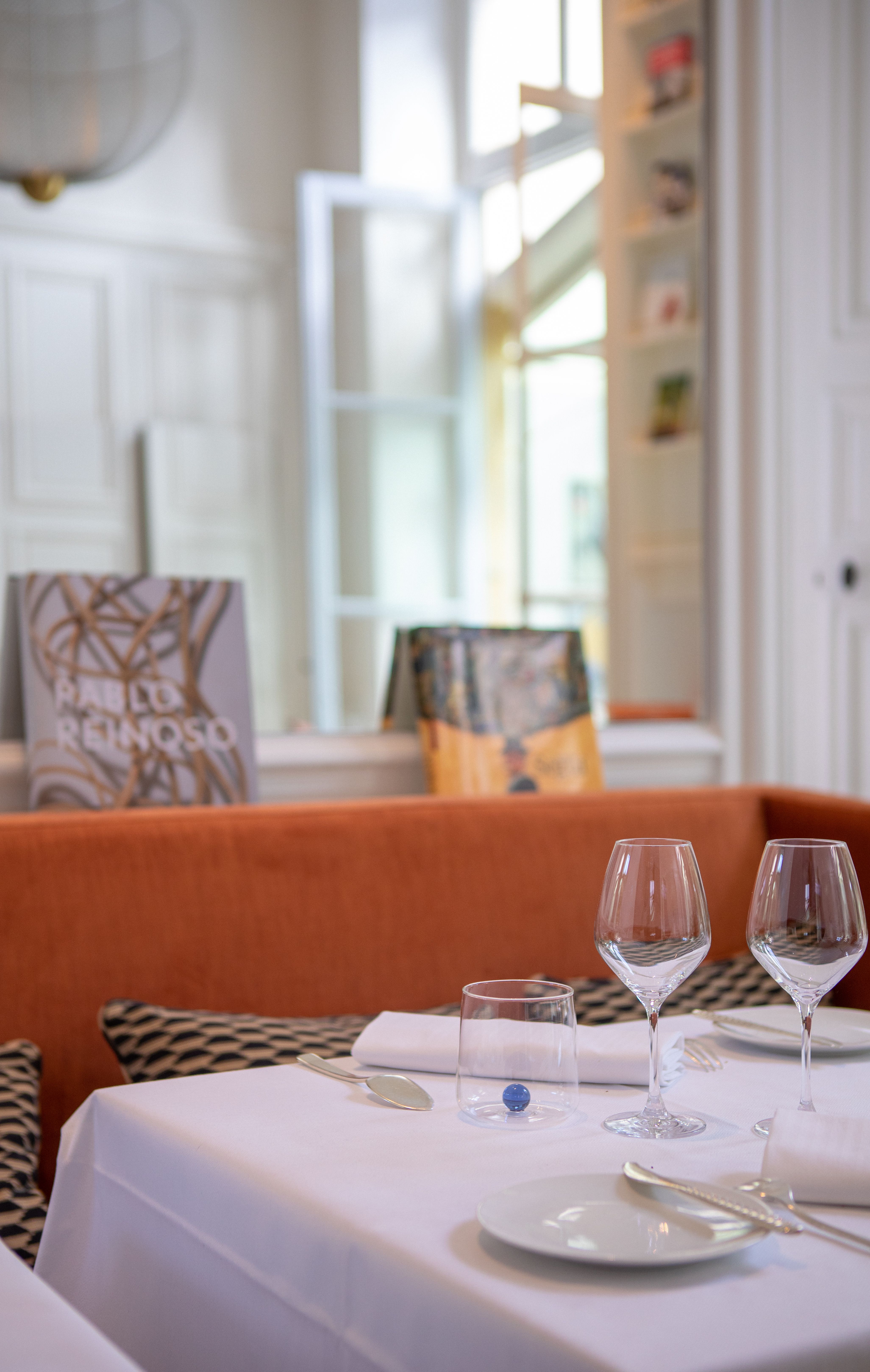 Salle gastronomique aux banquettes orange et livres d'art