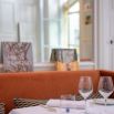 Salle gastronomique aux banquettes orange et livres d'art