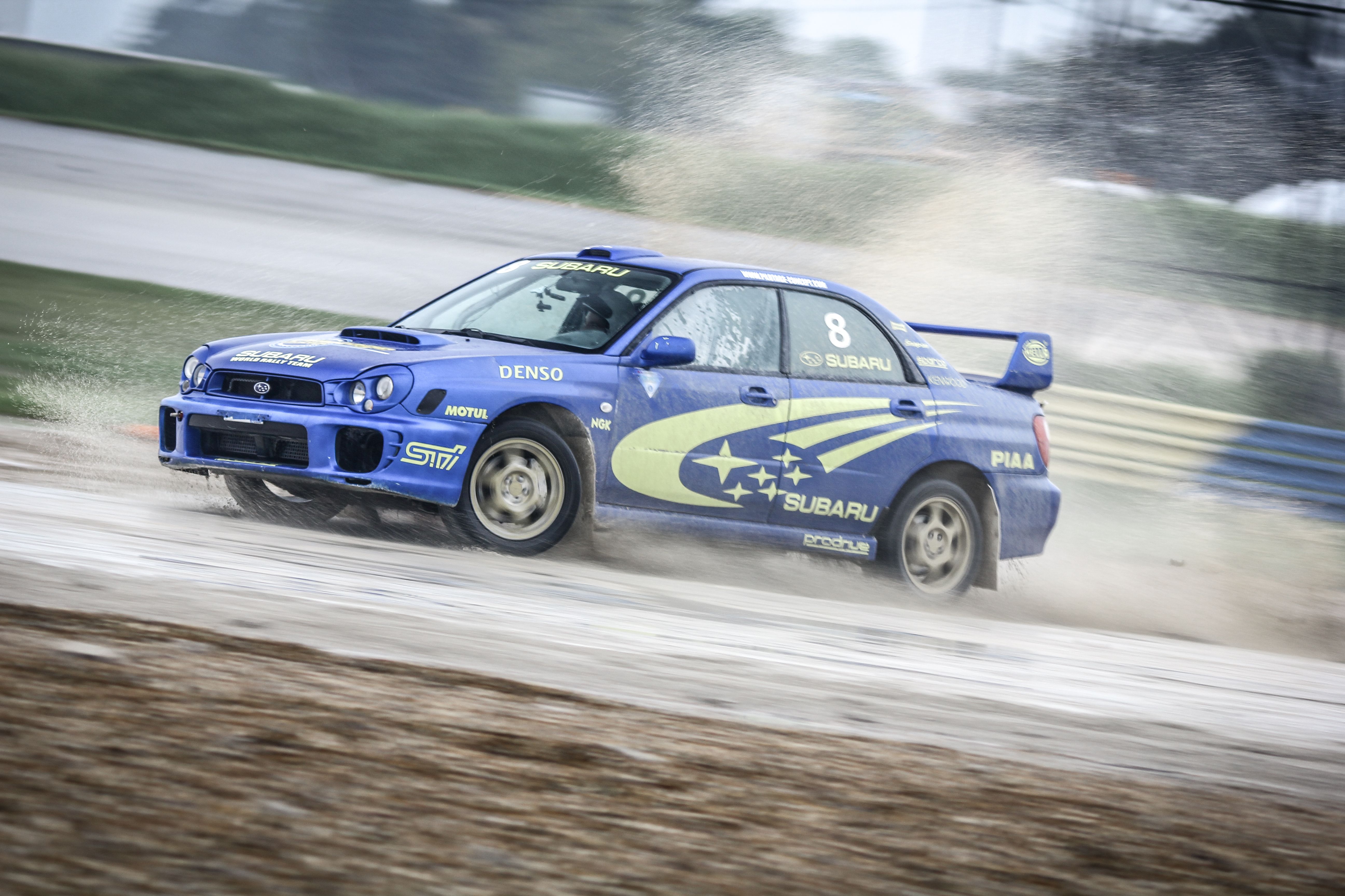 Subaru Impreza bleue en glisse sur piste mouillée
