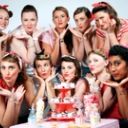 Groupe pin-up posant autour d'une pyramide de cupcakes