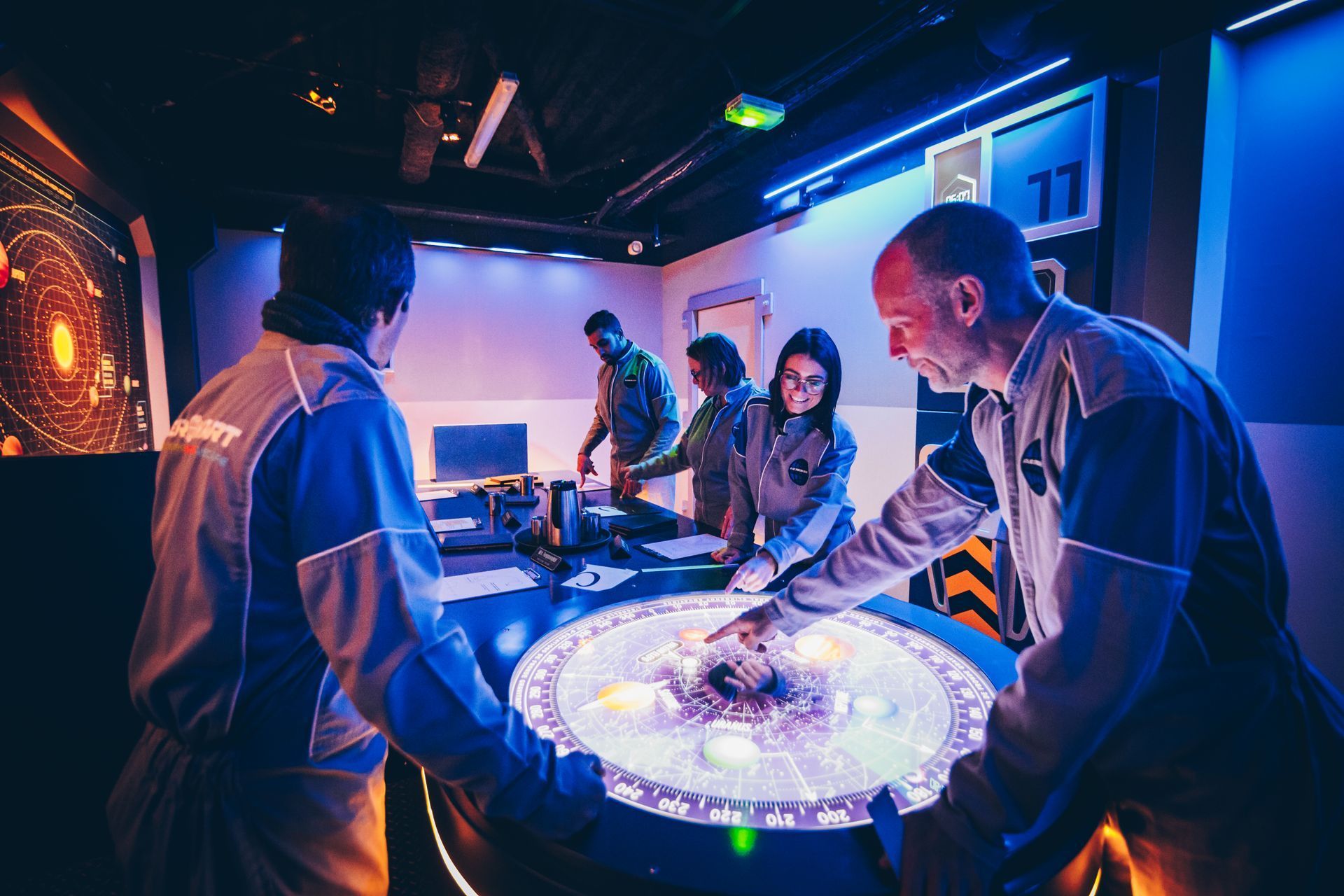 Equipe en escape game spatial autour table interactive