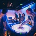 Equipe en escape game spatial autour table interactive