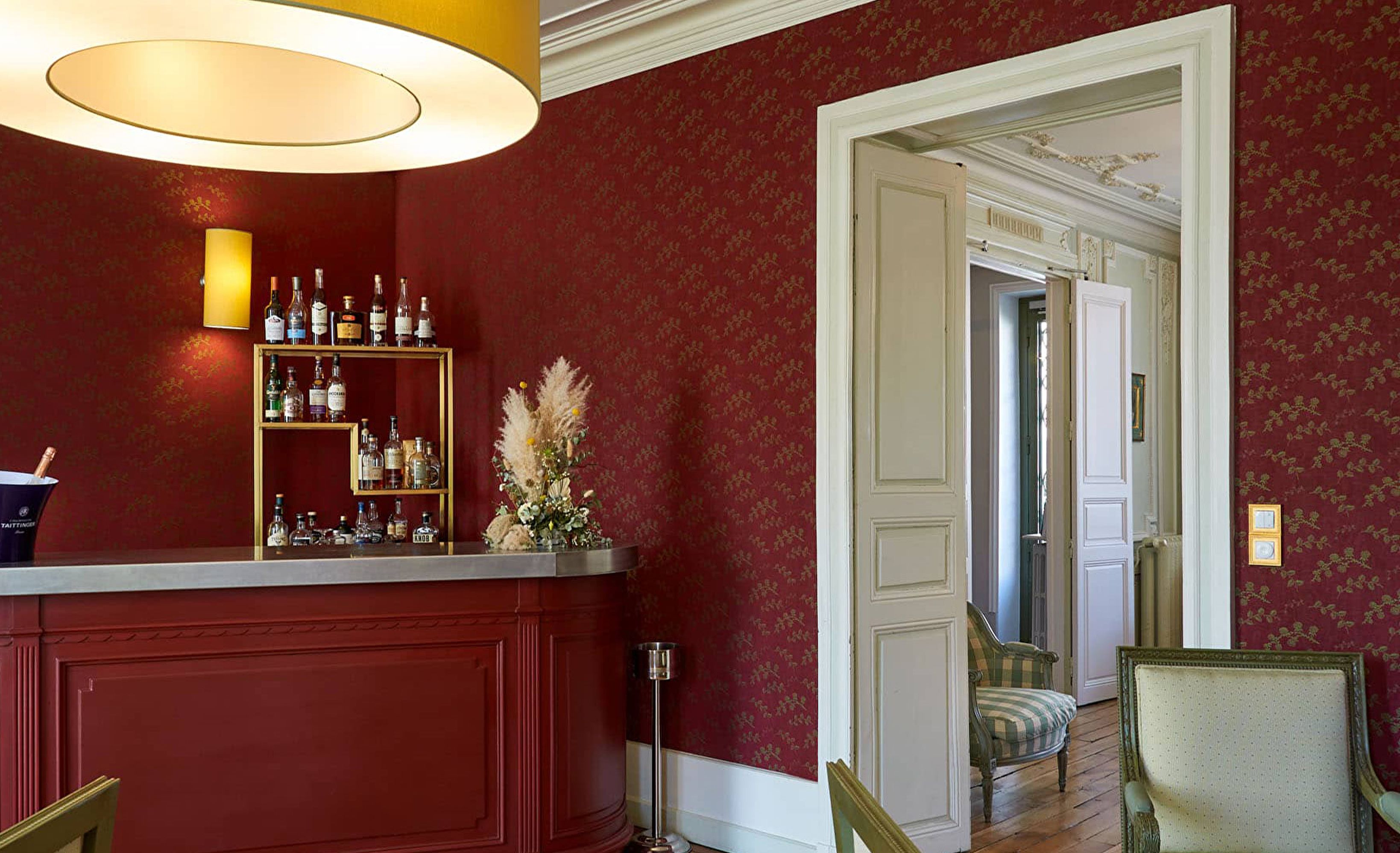 Salon bar tapissé rouge avec étagères de spiritueux