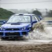 Subaru Impreza bleue éclaboussant la flaque pluie