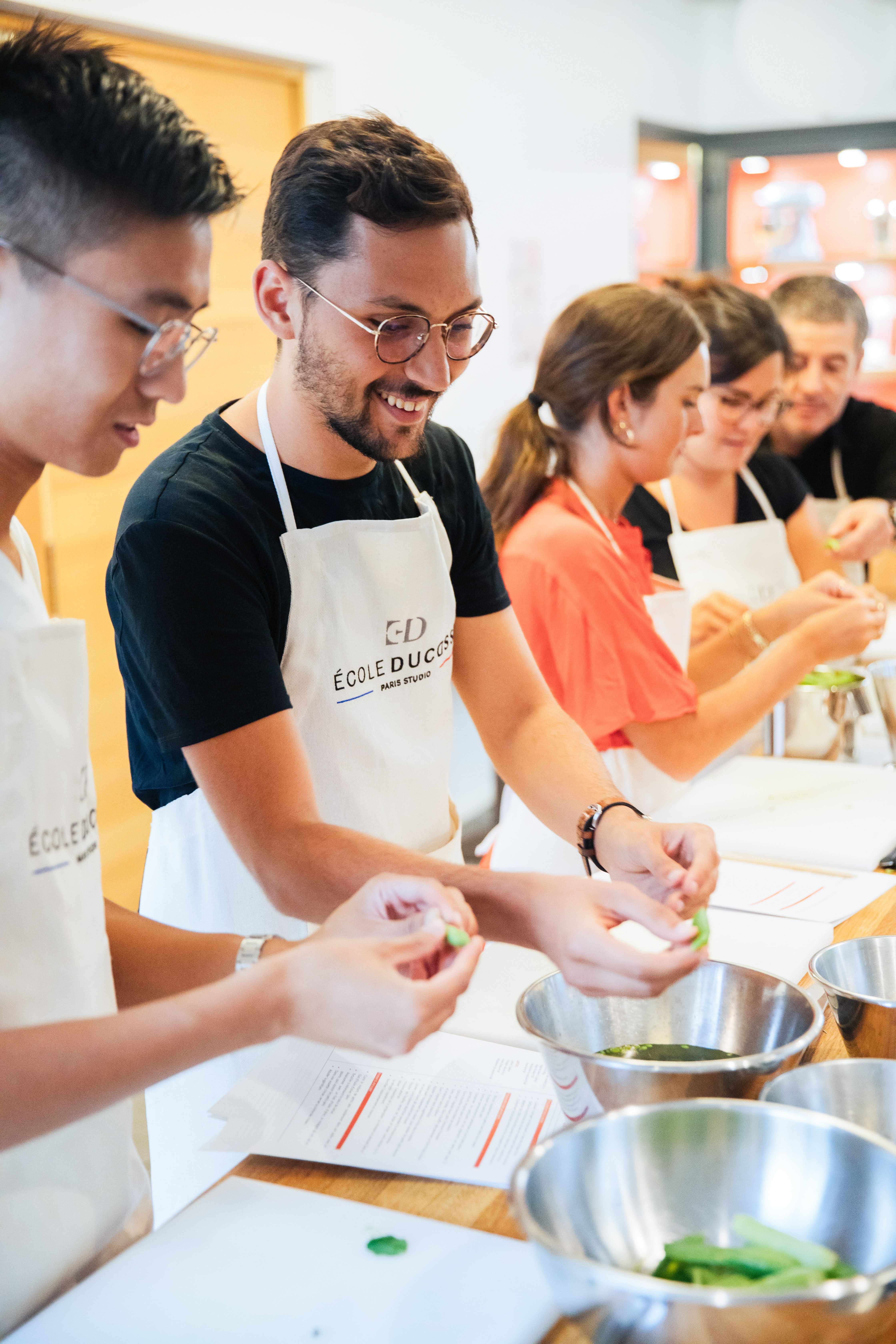 Élèves rieurs en cours de cuisine École Ducasse