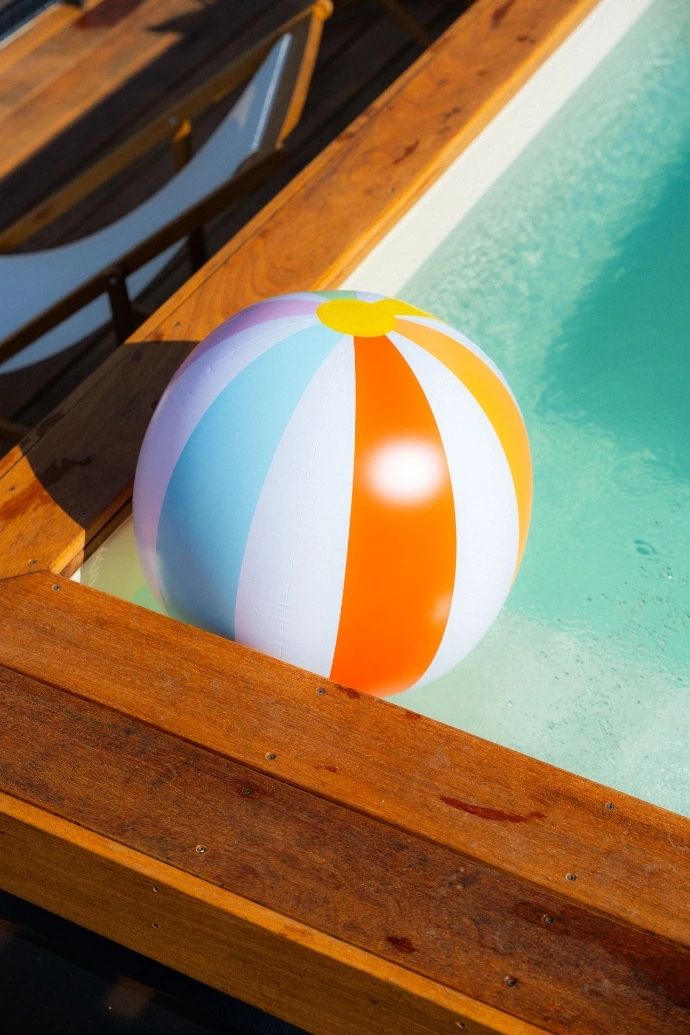 Ballon gonflable rayé flottant dans une piscine