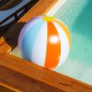 Ballon gonflable rayé flottant dans une piscine