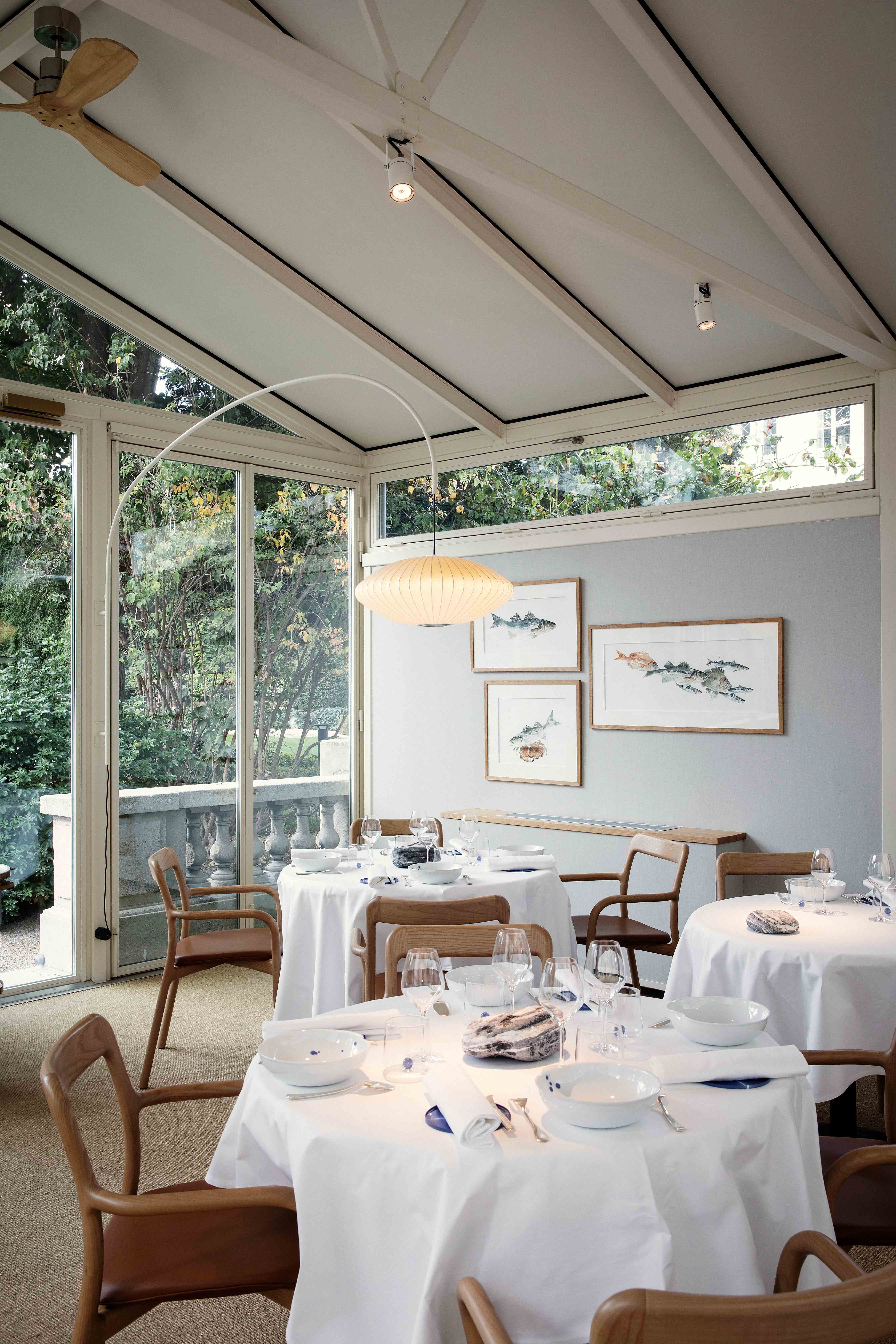 Salle à manger lumineuse avec véranda et tables dressées