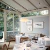 Salle à manger lumineuse avec véranda et tables dressées