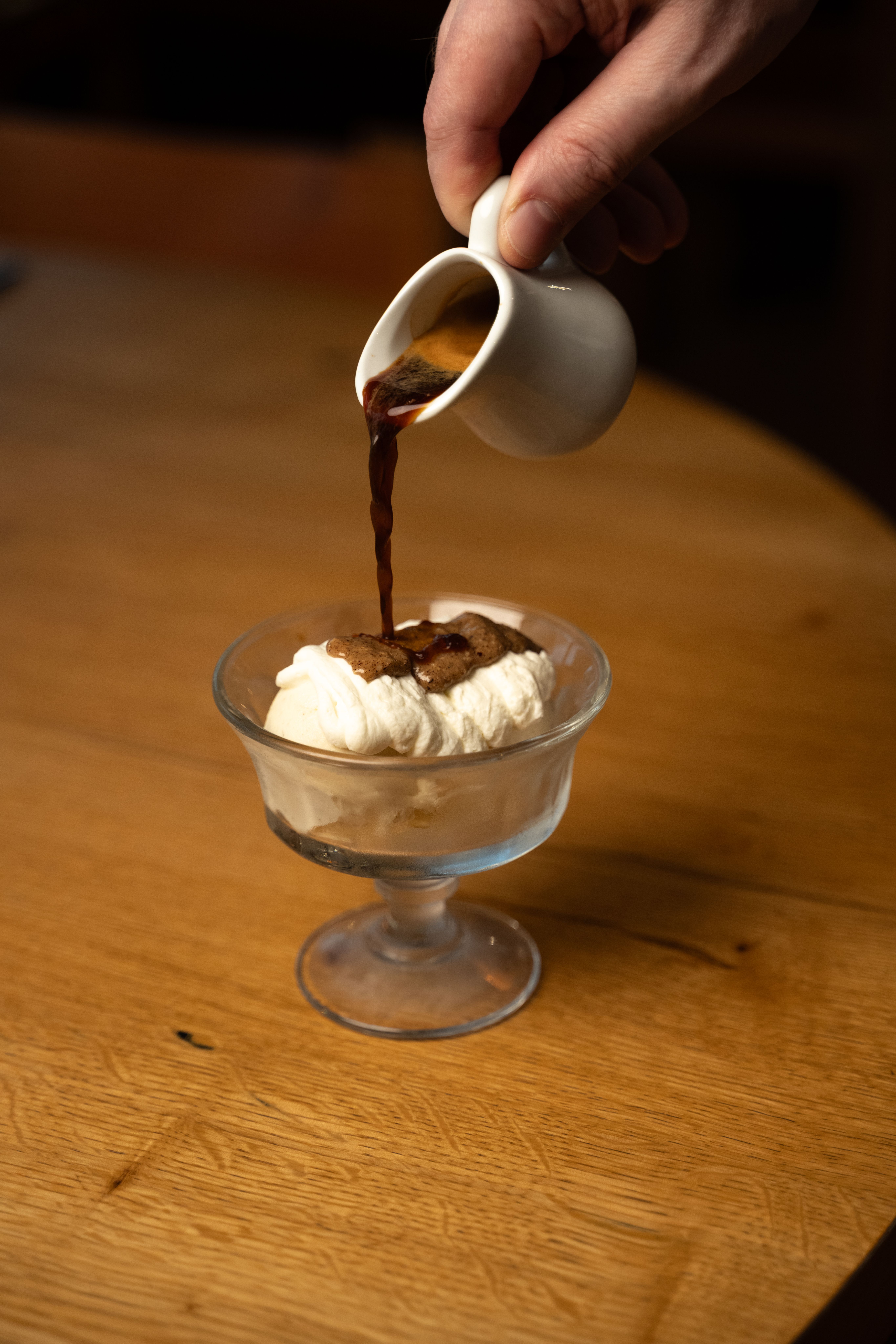 Versement d'un café chaud sur une coupe glacée affogato