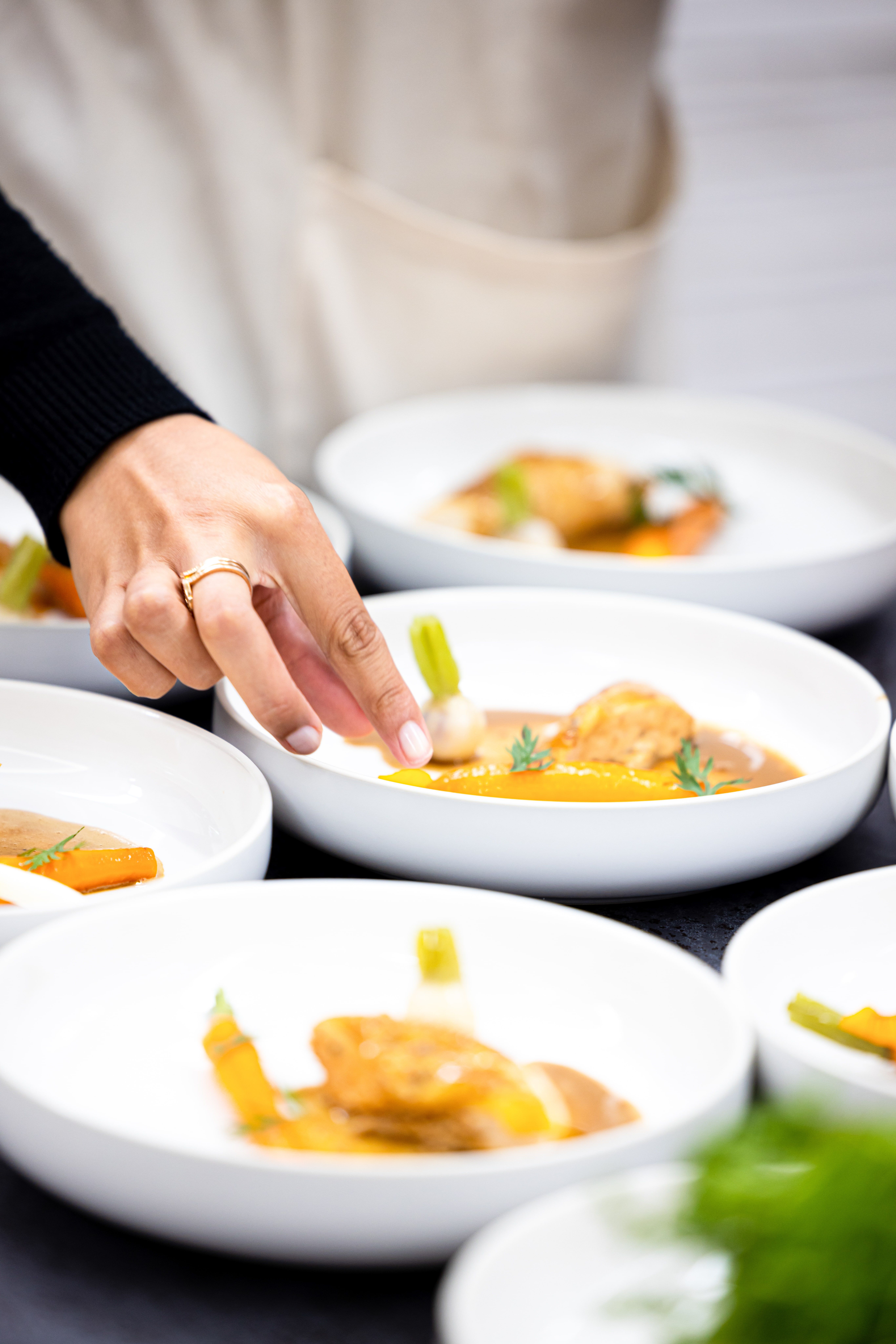 Cheffe dressant une assiette gastronomique en cuisine