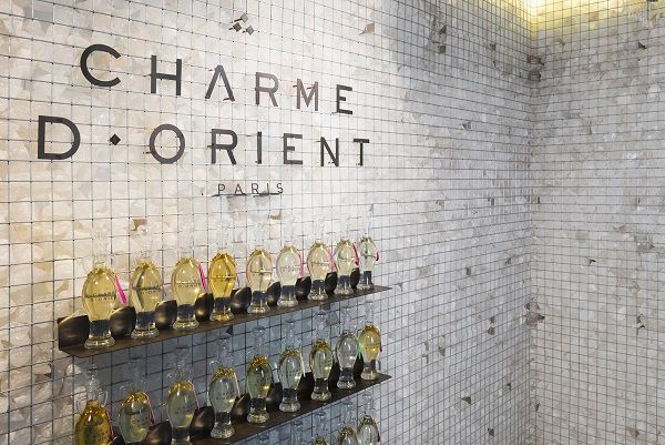 Mur de mosaïque blanche avec flacons d'huiles parfumées