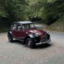 Citroën 2CV bordeaux stationnée en pleine forêt