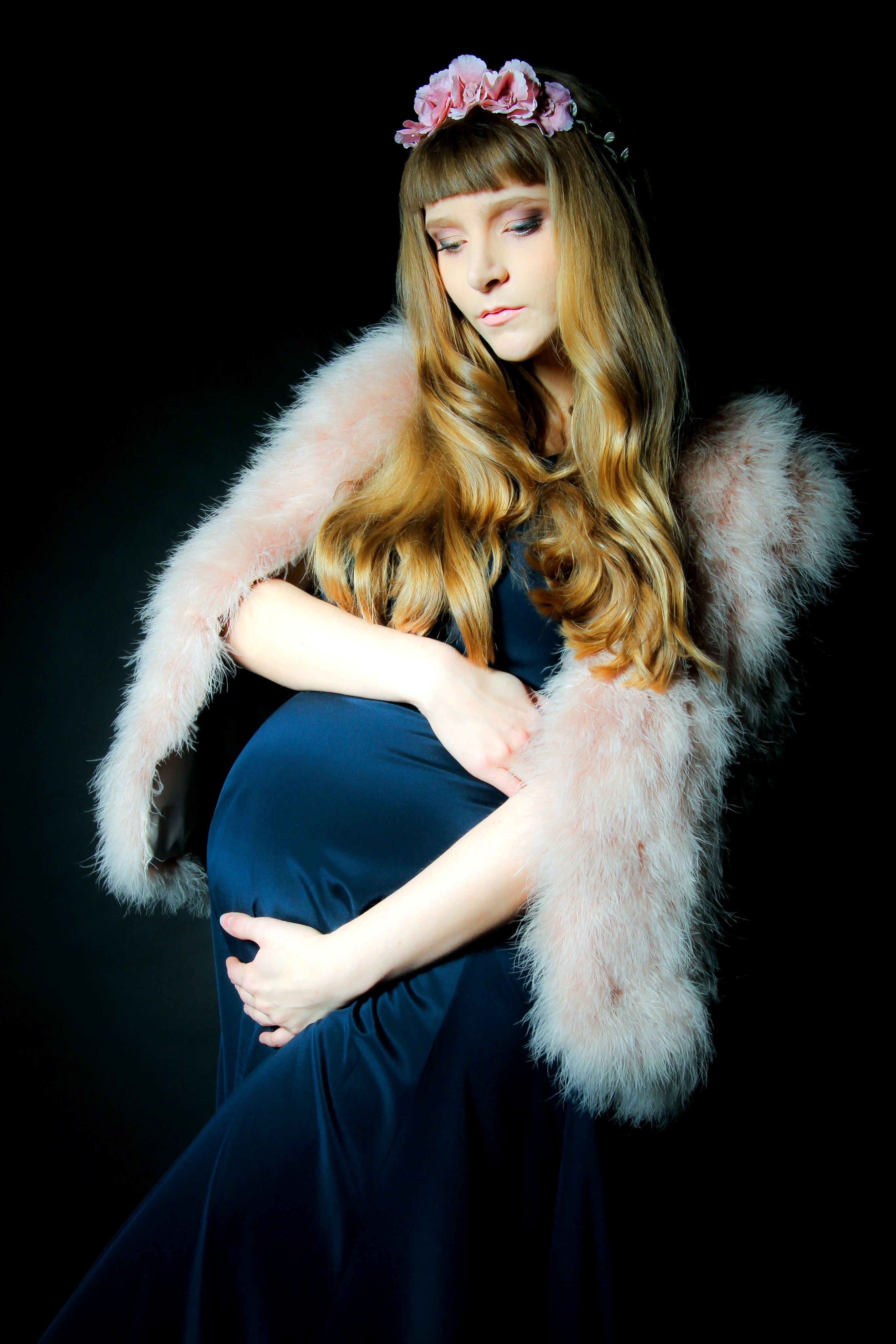 Portrait d'une femme enceinte en robe bleue et étole rose