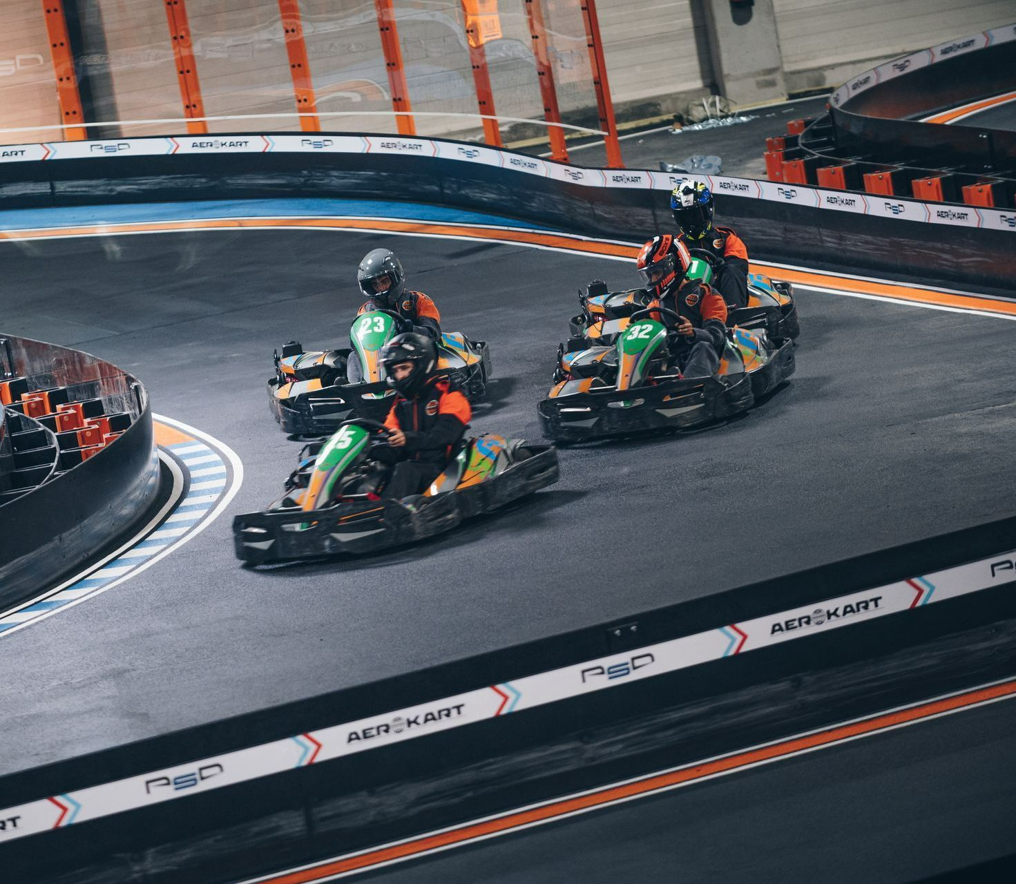 Pilotes en compétition de karting indoor sur piste éclairée