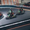 Pilotes en compétition de karting indoor sur piste éclairée