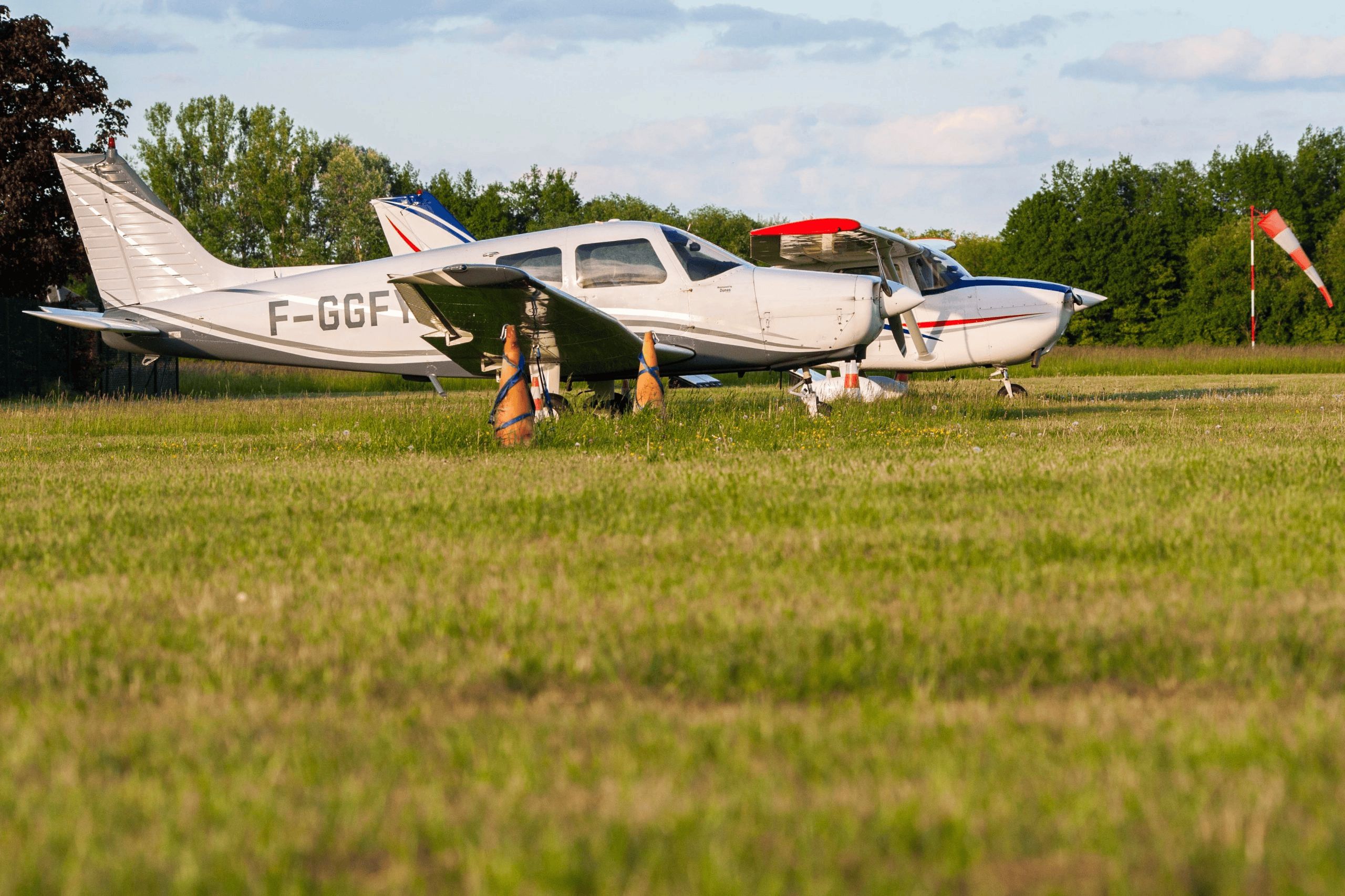 Avions de tourisme stationnés sur un aérodrome herbeux