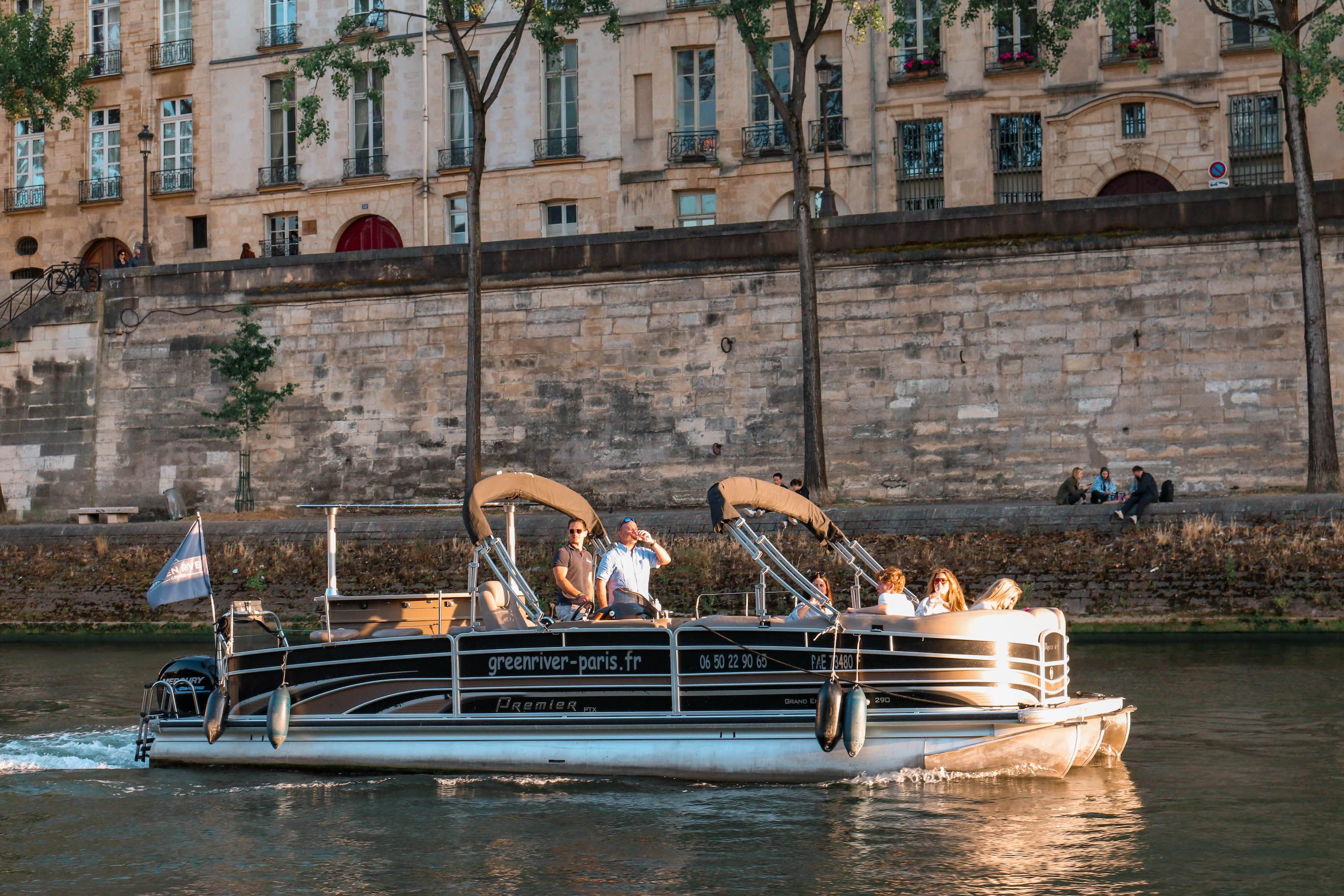 Bateau-ponton naviguant sur la Seine au pied des quais haussmanniens