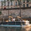 Bateau-ponton naviguant sur la Seine au pied des quais haussmanniens