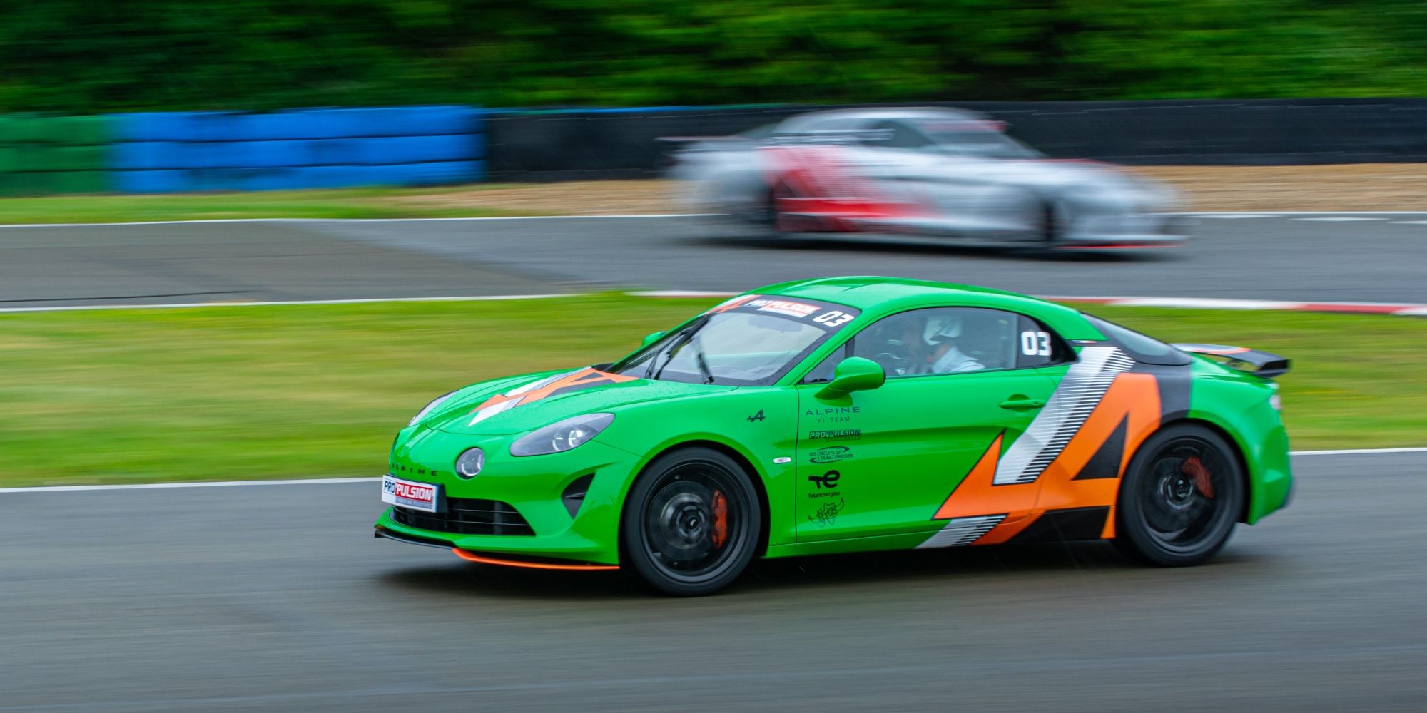 Alpine verte en course poursuivie par une seconde voiture