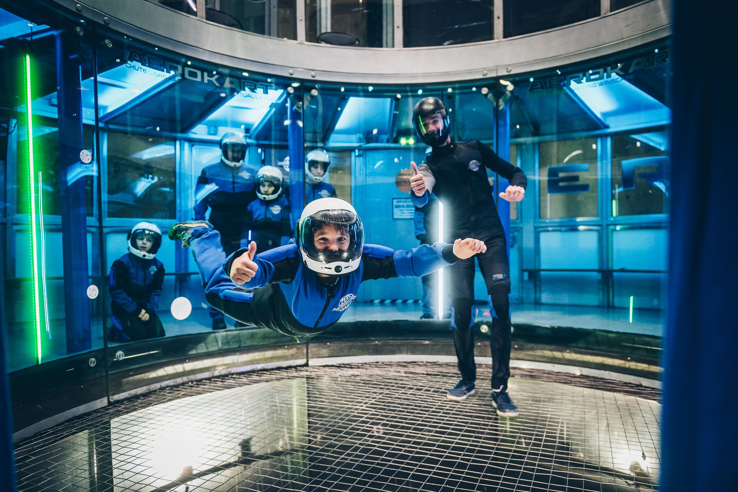 Pilote en vol stationnaire dans une soufflerie indoor bleue