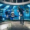 Pilote en vol stationnaire dans une soufflerie indoor bleue