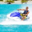 Pilote de jet-ski éclaboussant sur lagon turquoise tropical