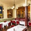 Salle de bistrot parisien avec moulures, tomettes et banquettes rouges