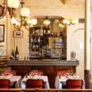 Salle de bistrot parisien aux lustres rétro et bar en miroir