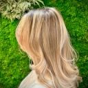 Coupe blond doré aux reflets sur fond végétal