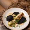 Plat gastronomique poireau brûlé et tuile noire