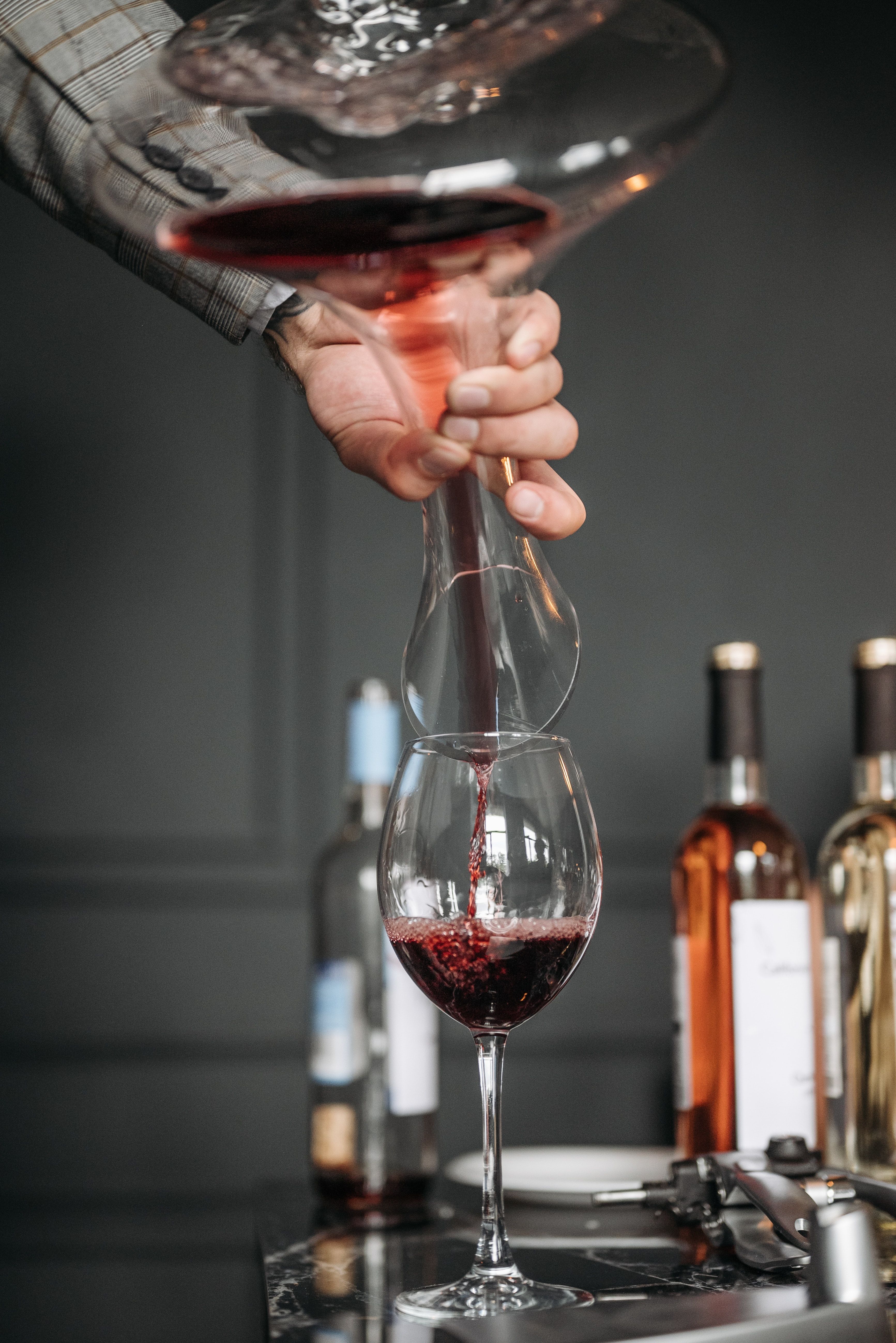 Sommelier décantant un vin rouge dans un verre