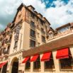Façade à colombages de l'Hôtel L'Espérance avec stores rouges