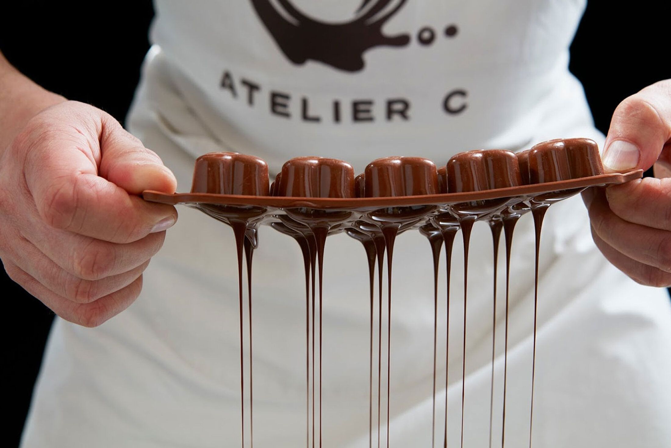 Chocolatier démoulant des bonbons en chocolat coulants