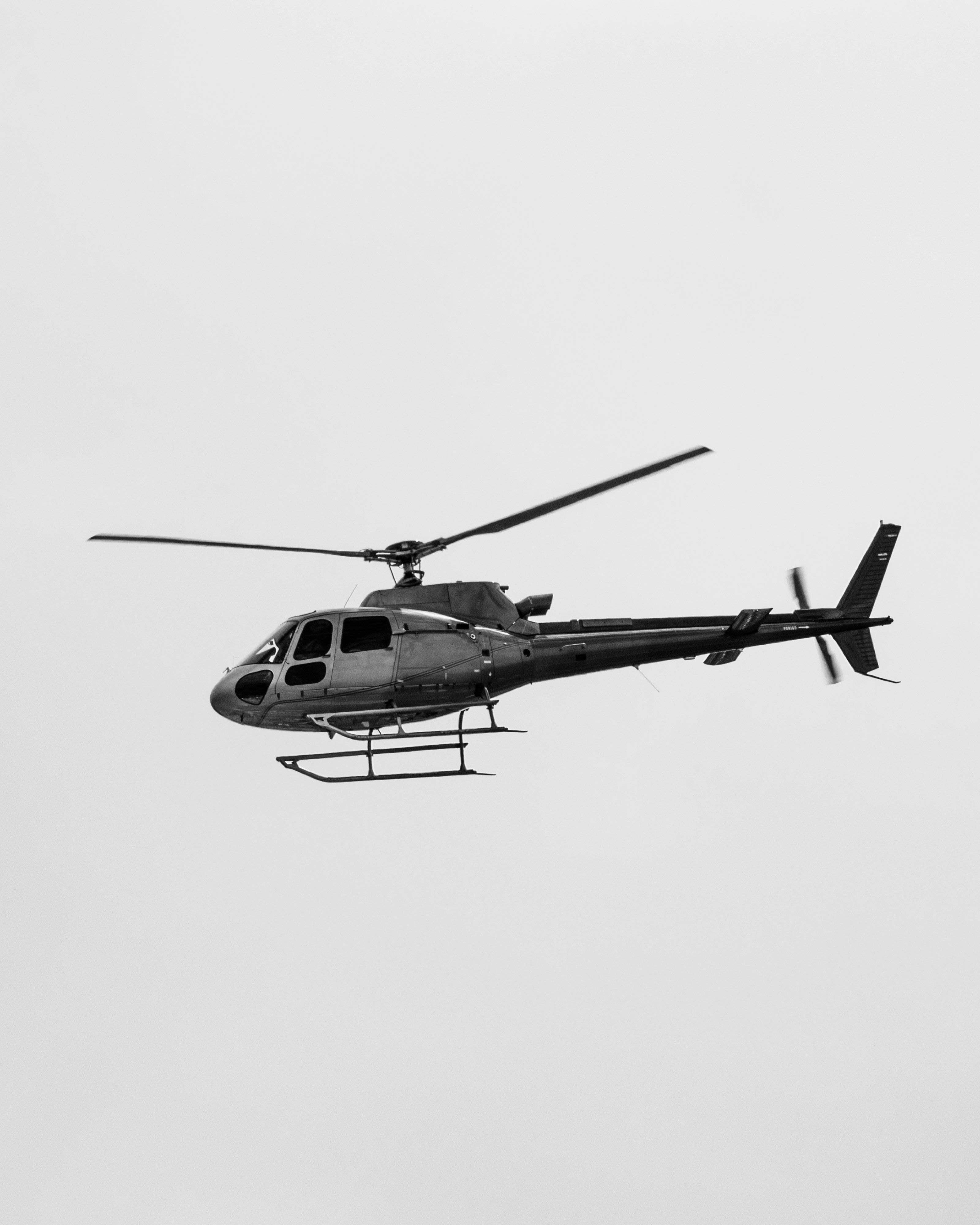 Hélicoptère en vol sur ciel blanc en noir et blanc